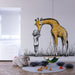 Une chambre d'enfant avec un papier peint illustrant une girafe jaune et un enfant en interaction, créant une atmosphère ludique et chaleureuse.