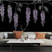 Un salon moderne avec un papier peint représentant des grappes de fleurs violettes sur fond noir, créant une atmosphère élégante et artistique.
