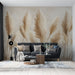 Un salon moderne avec un papier peint représentant des herbes pampas dans des teintes beige et doré, créant une atmosphère douce et naturelle.