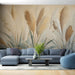 Un salon moderne avec un papier peint représentant des herbes pampas dans des teintes beiges et dorées, créant une atmosphère douce et naturelle.