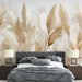Une chambre moderne avec un papier peint aux motifs de grandes herbes pampas dans des teintes beiges et dorées, créant une atmosphère douce et apaisante.