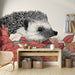 Une chambre accueillante avec un papier peint illustrant un hérisson stylisé parmi des feuilles colorées, créant une atmosphère chaleureuse et ludique.