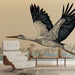 Une pièce moderne avec un papier peint illustrant une grande cigogne en vol, aux lignes épurées sur fond beige, créant une atmosphère artistique et naturelle.