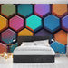 Une chambre moderne avec un papier peint hexagonal aux teintes vives et variées, créant une ambiance dynamique et artistique.