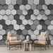 Un salon moderne avec un papier peint hexagonal en dégradé de gris, créant une ambiance élégante et contemporaine.