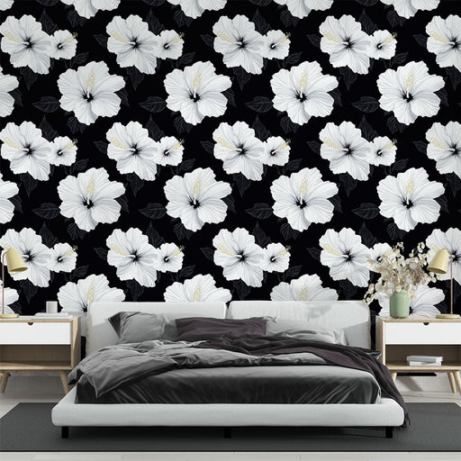 Une chambre moderne avec un papier peint floral noir et blanc, mettant en valeur de grandes fleurs d'hibiscus sur fond sombre, créant une atmosphère élégante et apaisante.