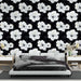Une chambre moderne avec un papier peint floral noir et blanc, mettant en valeur de grandes fleurs d'hibiscus sur fond sombre, créant une atmosphère élégante et apaisante.