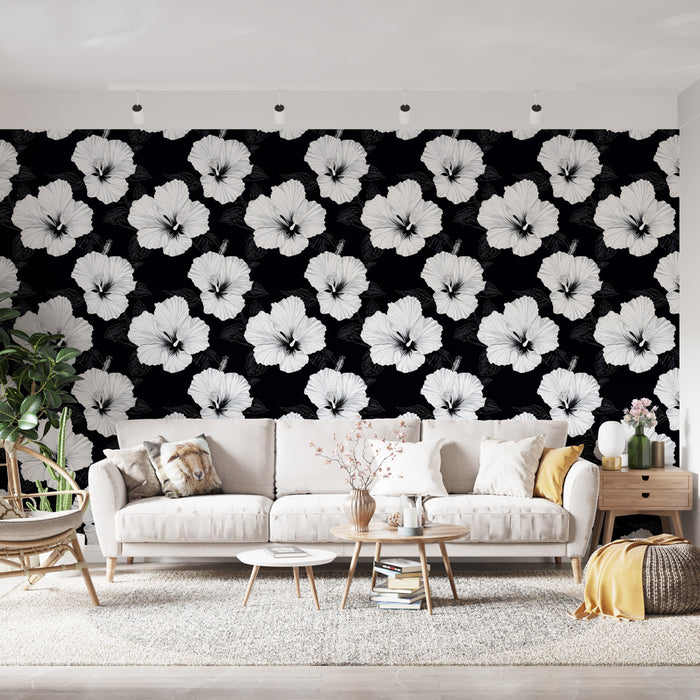 Un salon moderne avec un papier peint floral noir et blanc représentant de grandes fleurs d'hibiscus, créant une ambiance élégante et dynamique.