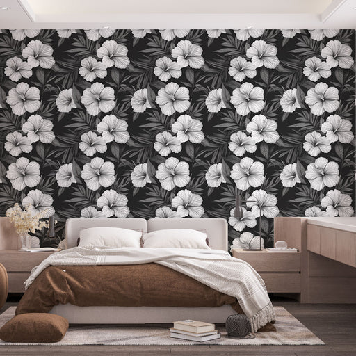 Une chambre moderne avec un papier peint floral noir et blanc, présentant de grandes fleurs et des feuilles, créant une atmosphère élégante et apaisante.