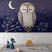 Une chambre d'enfant avec un papier peint illustrant une chouette endormie sur une branche, dans des teintes de bleu nuit et beige, créant une atmosphère douce et apaisante.