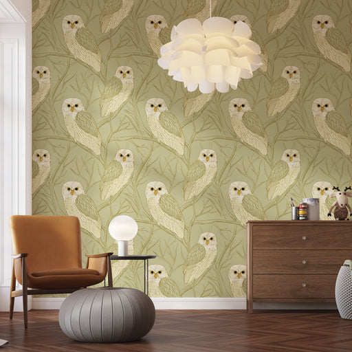 Une pièce chaleureuse avec un papier peint représentant des hiboux aux teintes douces sur un fond vert, créant une atmosphère apaisante et naturelle.
