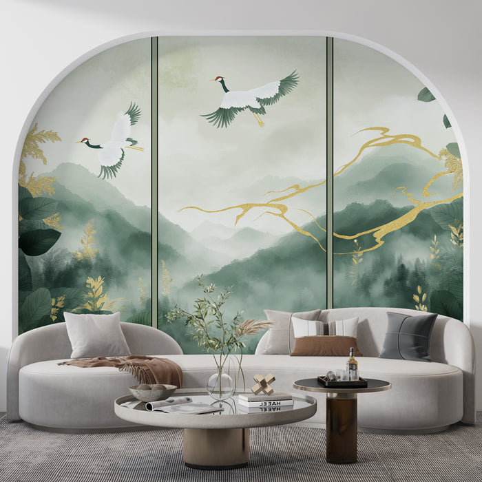 Un salon élégant avec un papier peint représentant des montagnes brumeuses et des grues, mêlant des teintes de vert et des touches dorées pour une ambiance apaisante et poétique.