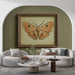 Un salon moderne avec un papier peint vert olive qui crée une atmosphère chaleureuse, accentuée par un tableau illustrant un papillon aux teintes orangées.