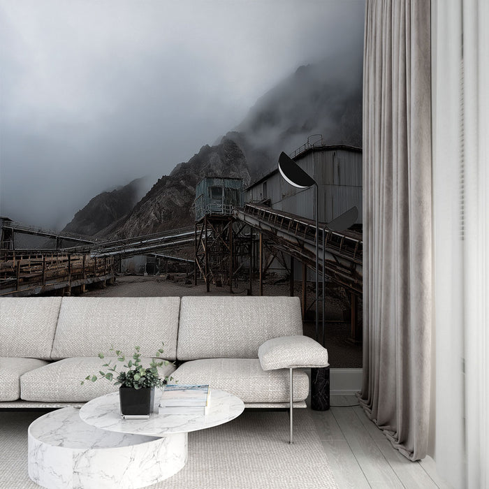 Une pièce moderne avec un papier peint industriel représentant un paysage de montagne brumeux et des structures métalliques, créant une ambiance à la fois mystérieuse et contemporaine.