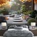 Une chambre moderne avec un papier peint représentant un jardin zen apaisant, mêlant pierres, gravier et végétation luxuriante dans des teintes naturelles.