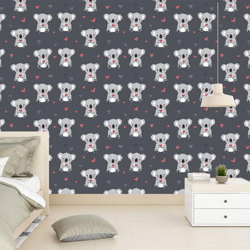 Une chambre enfantine avec un papier peint ludique représentant des koalas mignons sur fond gris, créant une atmosphère joyeuse et chaleureuse.