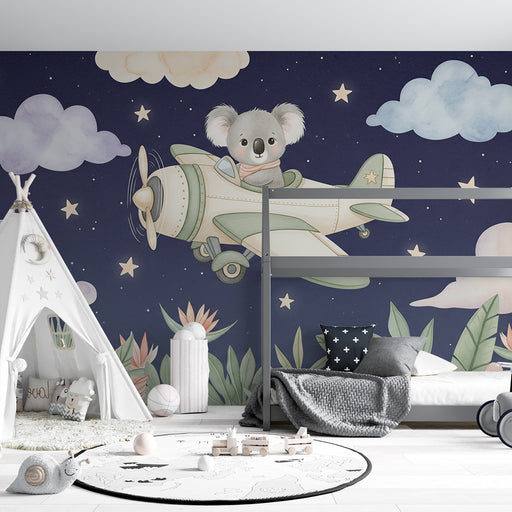 Une chambre d'enfant avec un papier peint illustrant un koala volant dans un avion sur fond étoilé, créant une ambiance ludique et rêveuse.