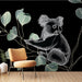 Une pièce moderne avec un papier peint représentant un koala stylisé sur fond noir, entouré de feuilles délicates aux teintes vertes, créant une ambiance ludique et contemporaine.