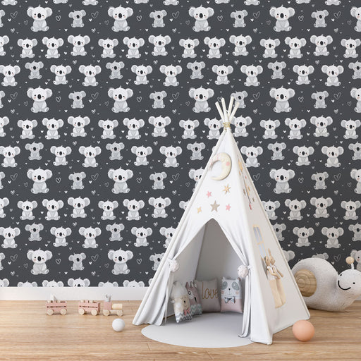 Une chambre d'enfant avec un papier peint ludique représentant des koalas sur fond gris, créant une atmosphère douce et joyeuse.