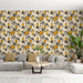 Un salon lumineux avec un papier peint floral aux motifs de branches noires et de fruits jaunes sur fond beige, créant une ambiance chaleureuse et accueillante.