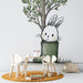 Une chambre d'enfant avec un papier peint illustratif représentant un lapin mignon dans une botte verte, entouré d'un arbre stylisé, créant une ambiance ludique et joyeuse.