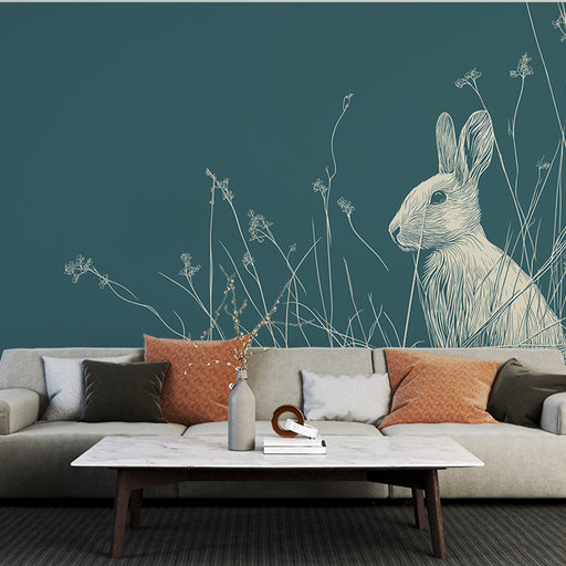Un salon moderne avec un papier peint illustrant un lapin délicatement dessiné en blanc sur fond bleu-vert, créant une ambiance douce et naturelle.