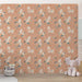 Une chambre d'enfant avec un papier peint rose saumon orné de licornes et de fleurs délicates, créant une atmosphère ludique et enchantée.