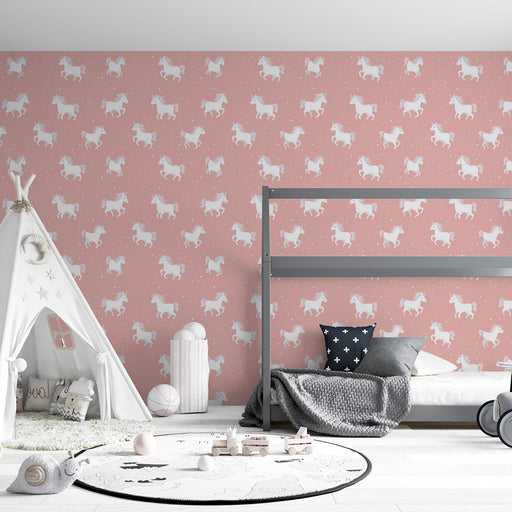 Une chambre d'enfant avec un papier peint rose illustré de licornes blanches sur un fond doux, créant une ambiance ludique et féerique.