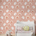 Une chambre d'enfant avec un papier peint rose illustré de têtes de licornes et d'arcs-en-ciel, créant une ambiance joyeuse et féerique.