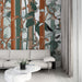 Un salon contemporain avec un papier peint illustrant des motifs de feuillage et de troncs d'arbres dans des teintes naturelles, créant une atmosphère apaisante et chaleureuse.