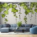 Un salon moderne avec un papier peint illustrant des feuilles vertes stylisées sur fond clair, créant une ambiance fraîche et naturelle.