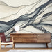 Une pièce moderne avec un papier peint abstrait aux lignes fluides et aux nuances de beige et de gris, créant une atmosphère élégante et apaisante.