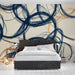 Papier peint lignes abstraites avec motif ondulé en bleu marine et touches de beige pour chambre moderne.