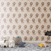 Une chambre d'enfant avec un papier peint illustré de lions stylisés sur fond beige, créant une ambiance ludique et chaleureuse.