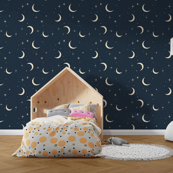 Une chambre enfantine avec un papier peint bleu nuit orné de croissants de lune et d'étoiles scintillantes, créant une ambiance rêveuse et apaisante.