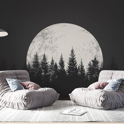 Une pièce moderne avec un papier peint représentant une grande lune blanche sur fond noir, entourée de silhouettes d'arbres, créant une atmosphère mystique et apaisante.