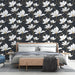 Une chambre élégante avec un papier peint floral représentant des magnolias blancs sur fond noir, créant une atmosphère raffinée et apaisante.