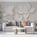Un salon moderne avec un papier peint représentant des fleurs stylisées blanches et dorées sur fond beige, créant une ambiance élégante et apaisante.