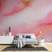 Une chambre moderne avec un papier peint abstrait aux dégradés de rose et des touches dorées, créant une ambiance douce et élégante.