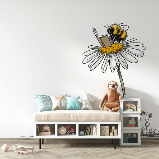 Une chambre d'enfant avec un papier peint illustratif représentant une abeille lisant sur une grande marguerite, créant une ambiance ludique et imaginative.