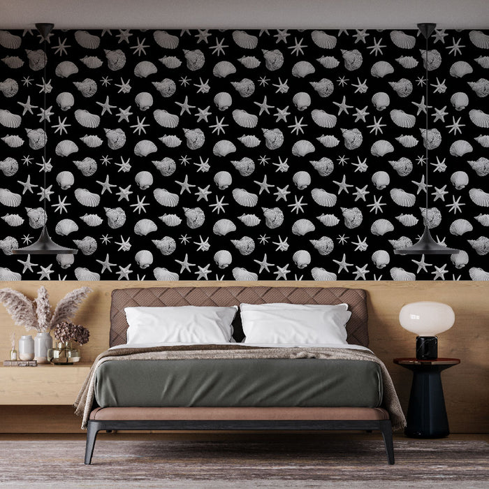 Une chambre moderne avec un papier peint noir orné de coquillages et d'étoiles de mer blanches, créant une ambiance marine élégante et apaisante.