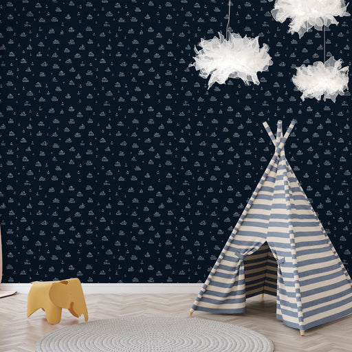 Une chambre d'enfant avec un papier peint navy illustré de petits bateaux et voiles blanches, créant une atmosphère ludique et maritime.