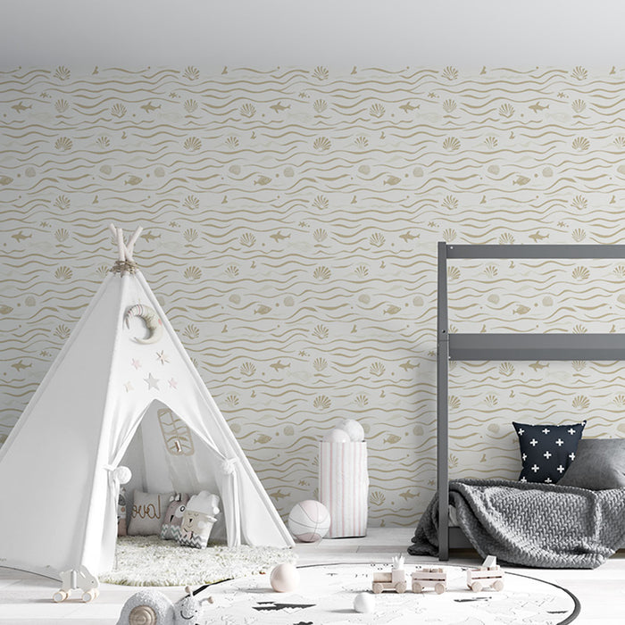 Une chambre d'enfant avec un papier peint aux motifs marins beige et doré, évoquant une ambiance douce et ludique avec des vagues et des coquillages.