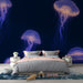 Papier peint chambre moderne avec méduses lumineuses flottant dans l'obscurité pour décoration murale unique.