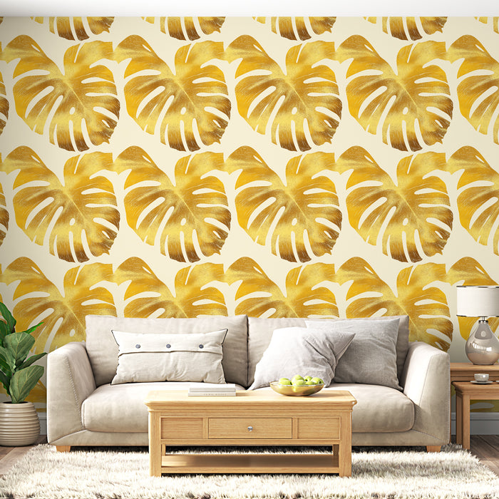Un salon moderne avec un papier peint tropical aux grandes feuilles monstera dorées sur fond clair, créant une ambiance chaleureuse et ensoleillée.