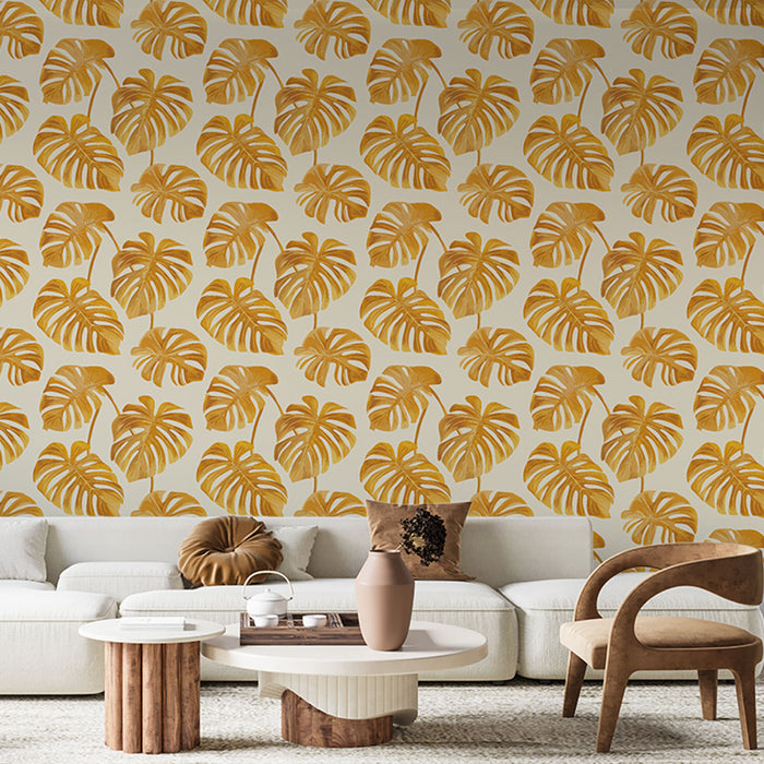 Un salon moderne avec un papier peint tropical aux motifs de grandes feuilles de monstera dorées sur fond clair, créant une ambiance chaleureuse et accueillante.