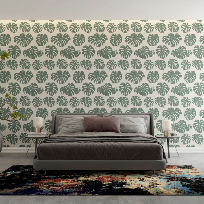 Une chambre moderne avec un papier peint tropical représentant des feuilles de monstera vertes sur fond clair, créant une atmosphère fraîche et apaisante.