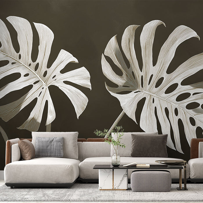 Un salon contemporain avec un papier peint représentant de grandes feuilles de monstera blanches sur fond brun, créant une ambiance élégante et naturelle.
