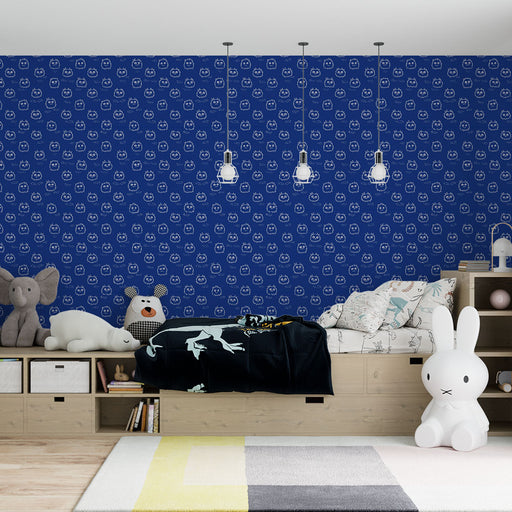 Une chambre d'enfant avec un papier peint bleu marine orné de motifs ludiques de visages souriants, créant une ambiance joyeuse et accueillante.