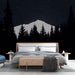 Une chambre moderne avec un papier peint représentant une montagne enneigée sous un ciel étoilé, créant une atmosphère apaisante et contemplative.